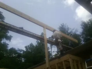Carpenter setting a ridge beam over a new addition frame — Ice Dam Removal by Roofing Brothers in Newmanstown