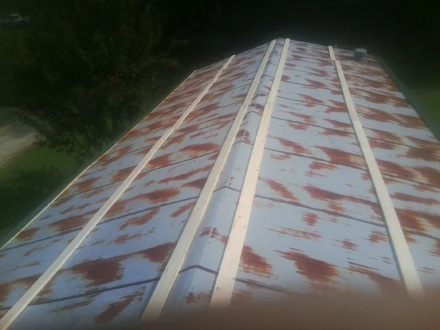 Rusted metal roof panels with new wood purlins before replacement — Storm Damage Roof Repair in Newmanstown by Roofing Brothers