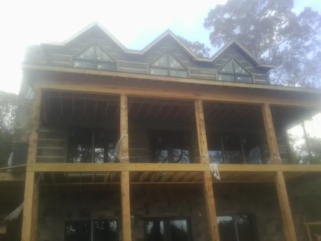 Dormers and porch framing on a large log home under construction — Roof Coating work by our crew in Newmanstown