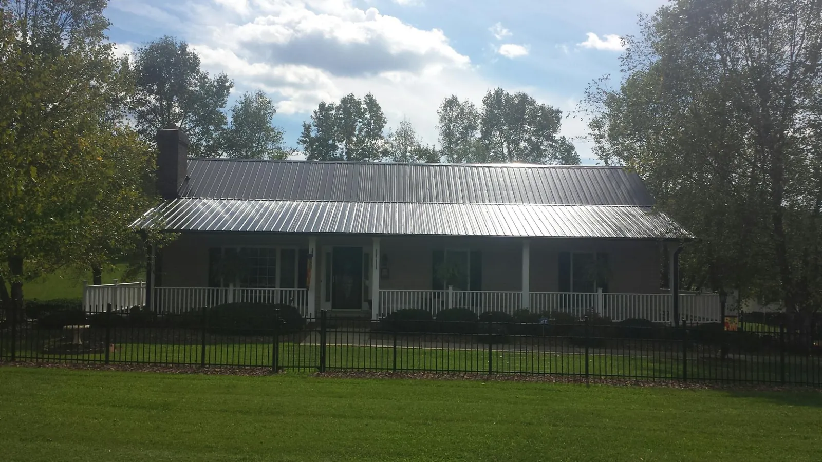 Gray metal roof on a brick ranch with a full width front porch — Gutter Guard Installation work by our crew in Newmanstown